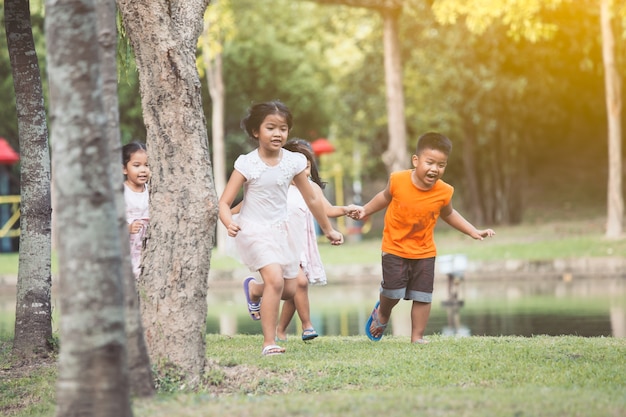 Enfants asiatiques s&#39;amuser à courir et jouer ensemble dans le parc dans le ton de couleur vintage