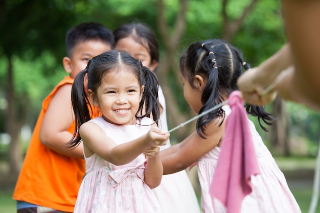 Enfants asiatiques s&#39;amuser à jouer au tir à la corde avec une corde ensemble dans le parc