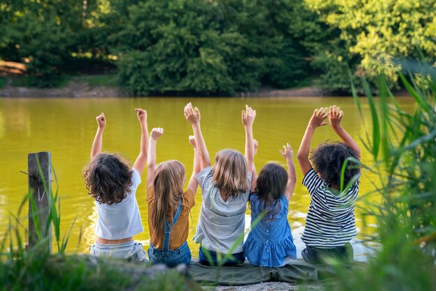 Enfants assis au bord du lac vue arrière