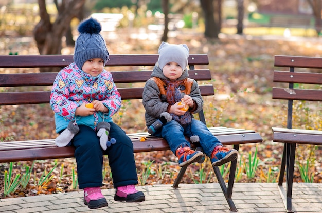 Enfants assis sur un banc dans le parc