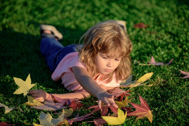 Les enfants d'automne tombent les feuilles en plein air