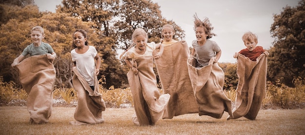 Enfants ayant une course en sac dans le parc