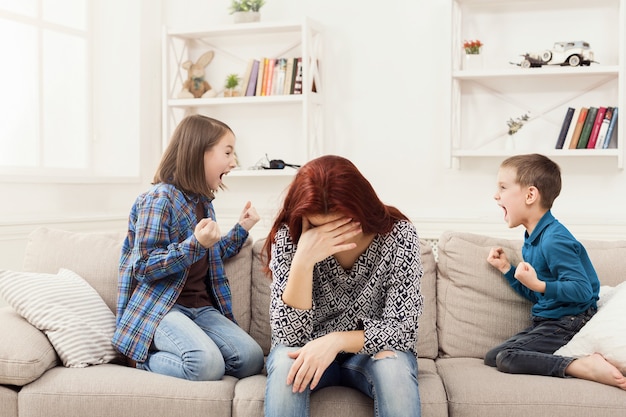 Enfants ayant querelle sur mère fatiguée