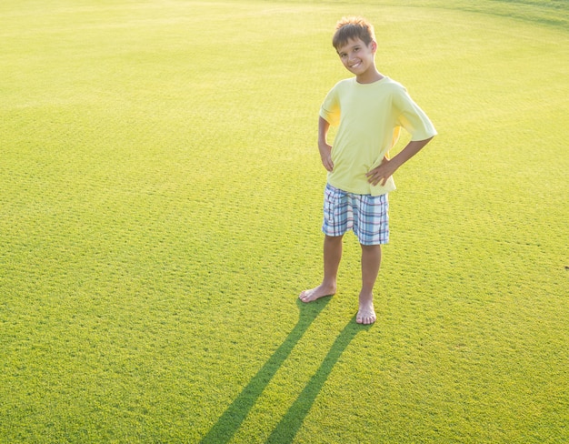 Enfants sur la belle prairie verte avec longues ombres