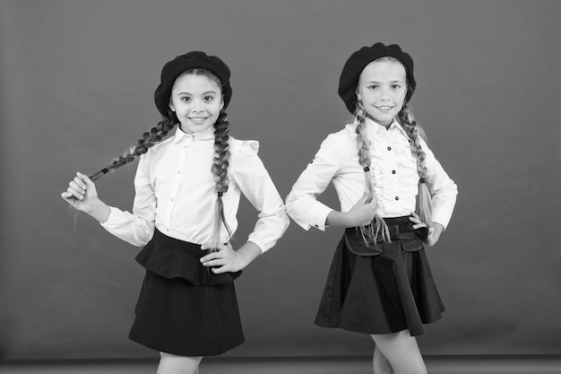 Enfants belles filles longs cheveux tressés Style fantaisie Petites filles avec des tresses prêtes pour l'école Concept de mode scolaire Amitié scolaire Sur la même vague Les écolières portent l'uniforme scolaire formel