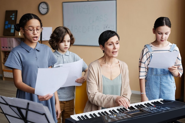 Enfants chantant des chansons avec le professeur