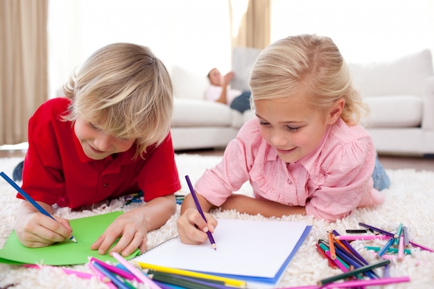 Enfants concentrés dessin allongé sur le sol