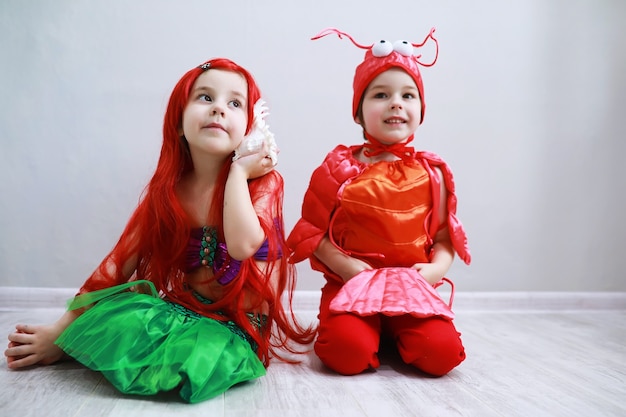 Enfants en costumes de carnaval intelligents sur fond uni Costume de créatures féeriques de la mer