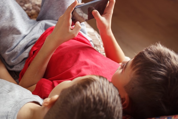 Enfants, coucher, jouer téléphone portable