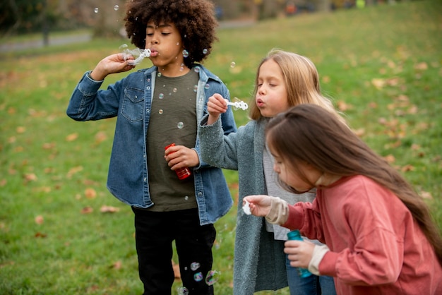 Enfants à coup moyen faisant des bulles de savon