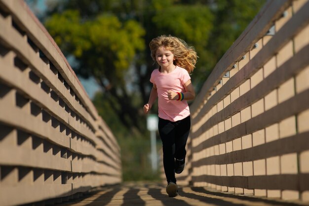 Enfants courant à l'extérieur Course et sport sain pour les enfants Enfant courant sur le terrain d'été près du lac enfant