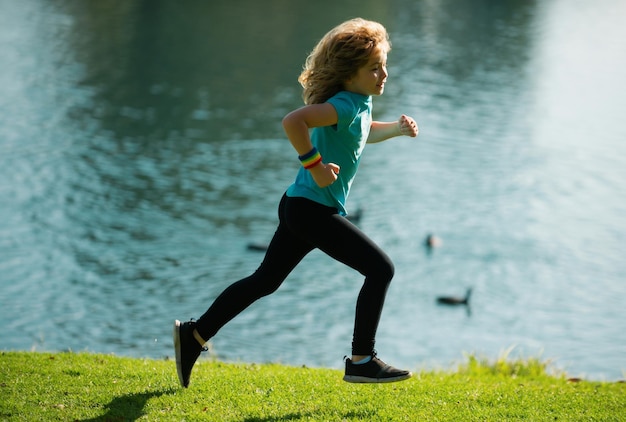 Photo enfants courant à l'extérieur course et sport sain pour les enfants enfant courant sur le terrain d'été près du lac enfant