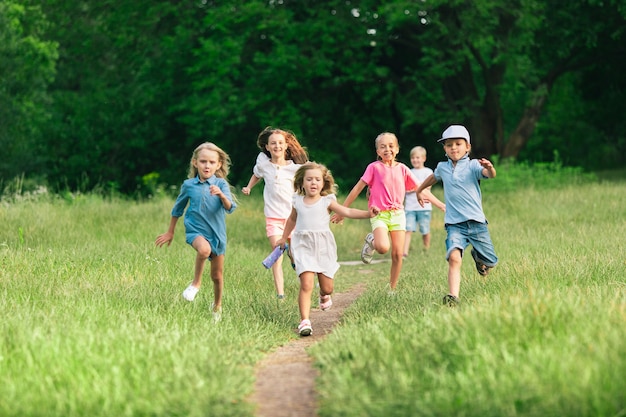 Enfants courant sur le pré avec la lumière du soleil d'été.