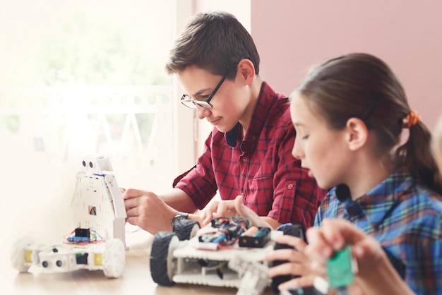 Enfants créant des robots à l'école, éducation à la tige, espace de copie. Développement précoce, bricolage, innovation, concept de technologie moderne