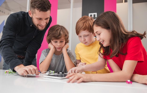 Enfants créatifs avec professeur étudiant la robotique