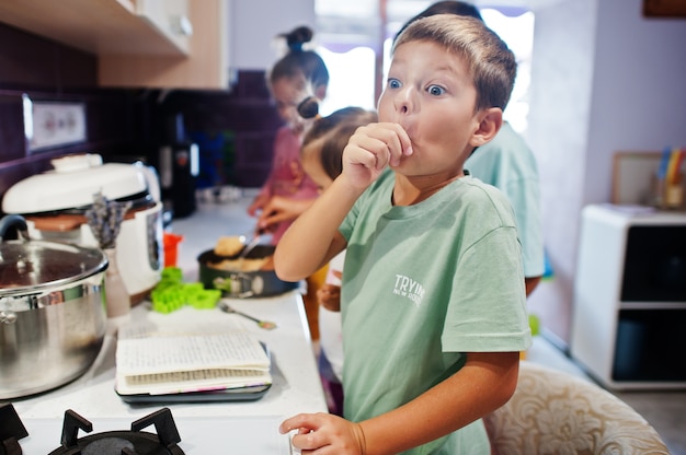 Enfants cuisinant à la cuisine, moments heureux pour les enfants. Délicieux lécher les doigts !