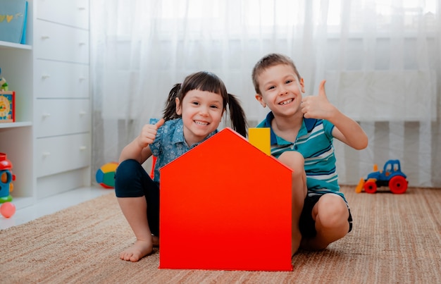 Enfants dans la crèche avec une maison de jouet rouge