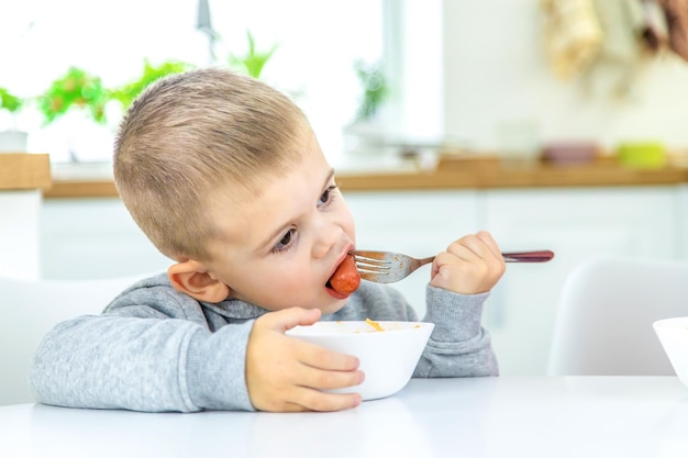 Enfants dans la cuisine à la table tournant la mise au point sélective des pâtes