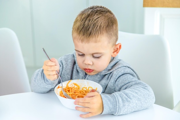 Enfants dans la cuisine à table tournant les pâtes