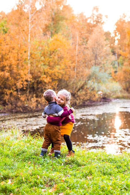 enfants dans la forêt d'automne sur un pique-nique grill saucisses et jouer de la guitare