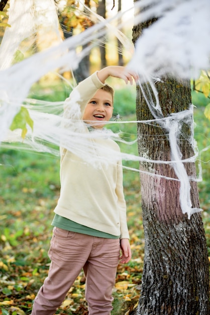 Enfants dans le parc d'automne, une toile d'araignée sur l'arbre.