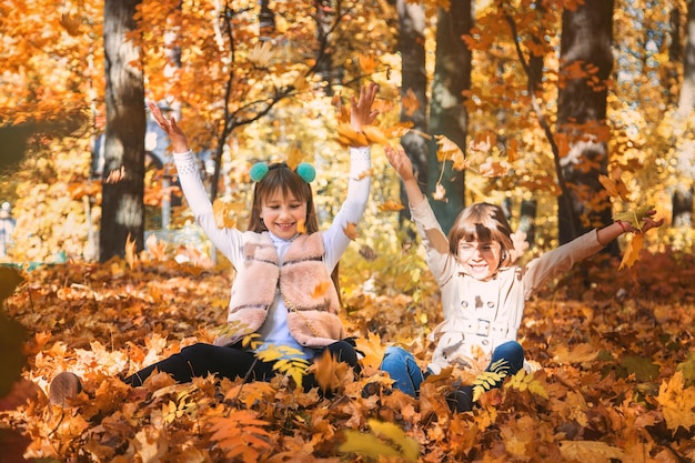 Enfants dans le parc avec des feuilles d'automne Mise au point sélective