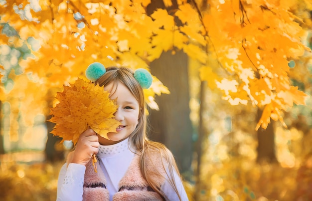 Enfants dans le parc avec des feuilles d'automne. Mise au point sélective.