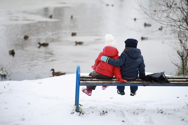 Photo les enfants dans le parc d'hiver jouent avec la neige