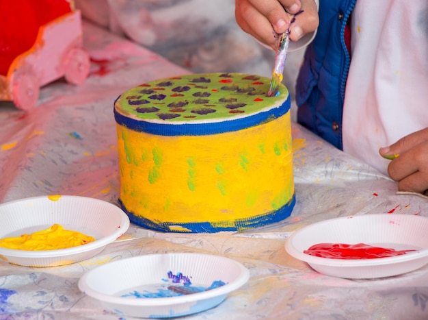 Des enfants décorant un tambour fait à la main