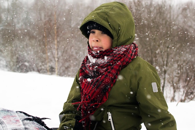 Les enfants descendent la colline. Garçon sur un tube. Plaisirs d'hiver dans l'enfance.