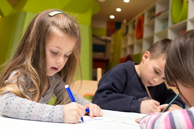 Enfants dessinant à la salle de jeux