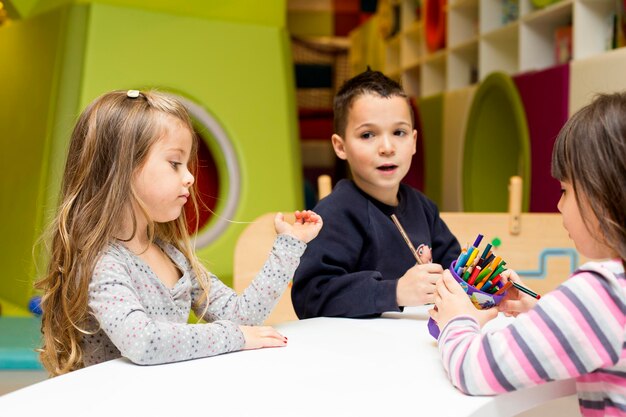 Enfants dessinant à la salle de jeux