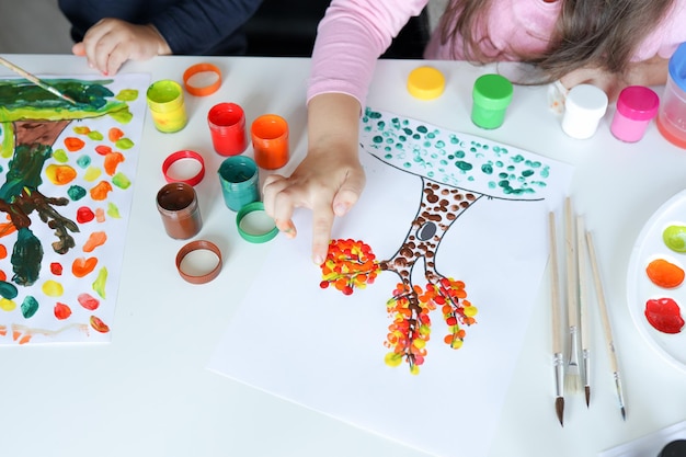 Les enfants dessinent des arbres avec des feuilles avec des peintures colorées Activités créatives