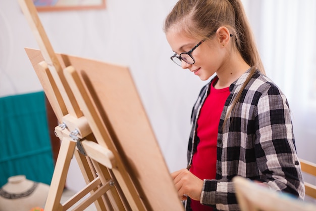 Les enfants dessinent sur un chevalet dans une école d'art.