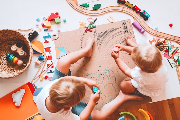 Les enfants dessinent et font de l'artisanat Enfants avec des jouets éducatifs et des fournitures scolaires pour la créativité