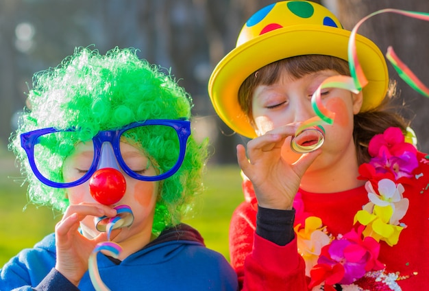 Enfants drôle de carnaval souriant et jouant en plein air