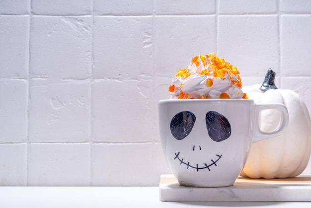 Enfants drôles chocolat chaud ou café au lait avec marshmallow et crème fouettée décoré avec la tasse de visage effrayant de Jack fête d'Halloween nourriture et boisson espace de copie