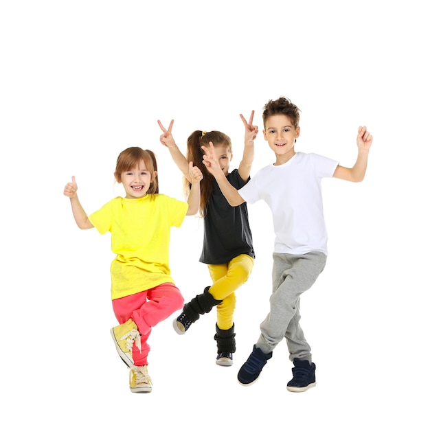 Enfants drôles mignons dansant sur une surface blanche