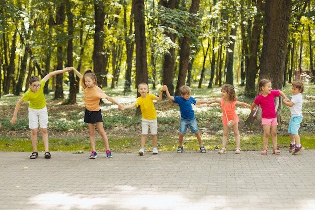 Les enfants du camp d'été font une vague main dans la main