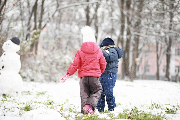 Les enfants du parc d'hiver jouent avec la neige