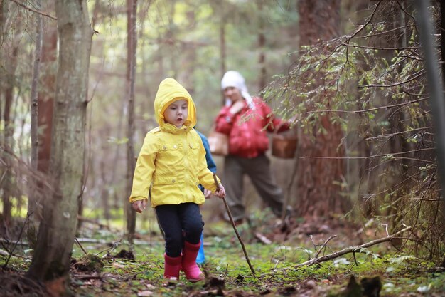 Les enfants du village se promènent dans la forêt d'automne et ramassent des champignons. Les enfants dans la nature marchent dans la nature. Balade champêtre en automne.