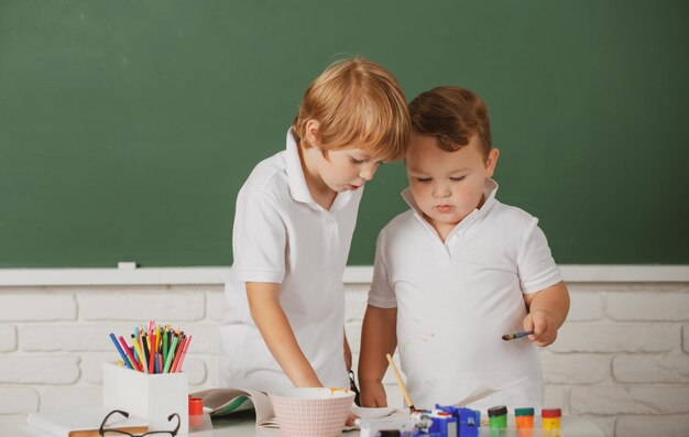 Les enfants de l'école Portrait bosy faisant leurs devoirs d'art tenant un crayon écrit enfants élèves s'appuyant sur eleme