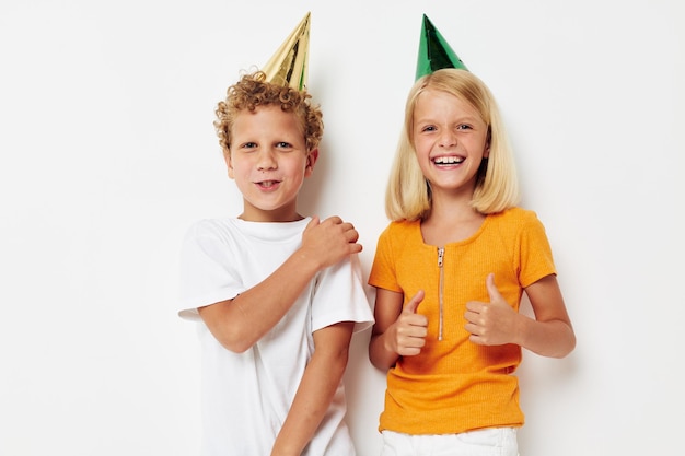 Enfants élégants mignons posant des émotions vacances casquettes colorées fond isolé inchangé