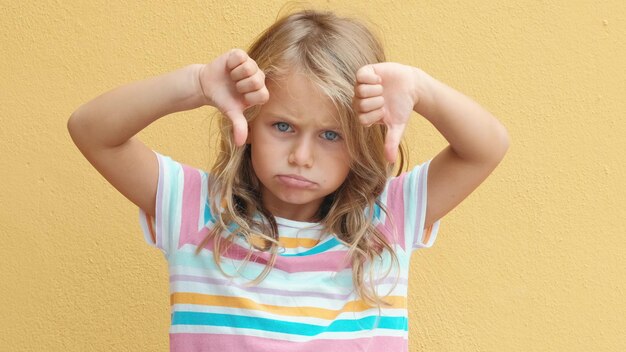 Photo les enfants émotions négatives petite fille émotionnelle avec signe de refus de dégoût.