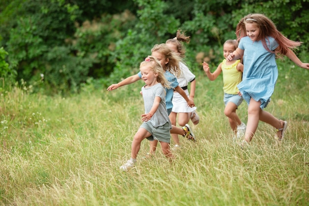 Enfants, enfants courant sur le pré vert