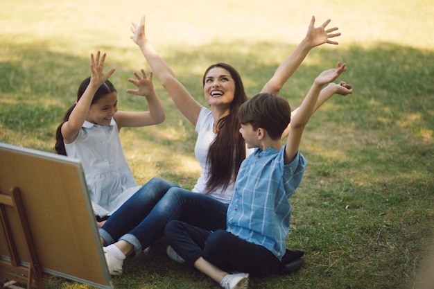 Enfants et enseignant posant avec les mains levées