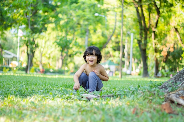 Les enfants d'environ 34 ans se déshabillent et jouent joyeusement dans le parc pendant les vacances