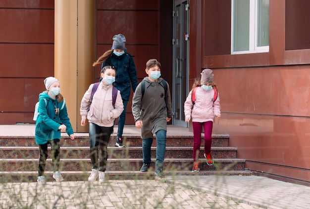 Les enfants étudiants masqués quittent l'école.