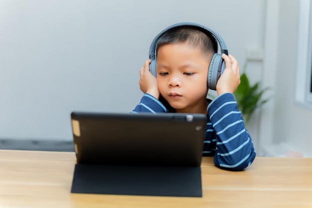 Les enfants étudient en ligne via des tablettes à la maison.