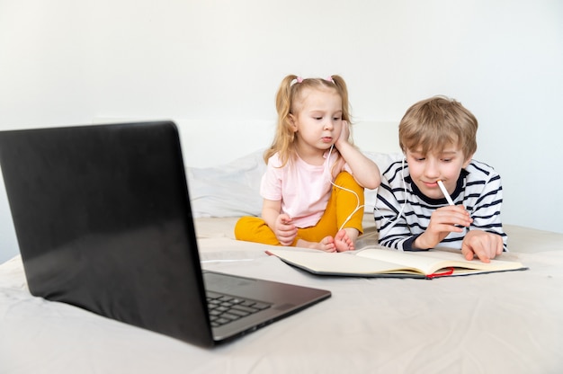 Enfants étudient à la maison à l'aide d'un ordinateur portable et d'un casque